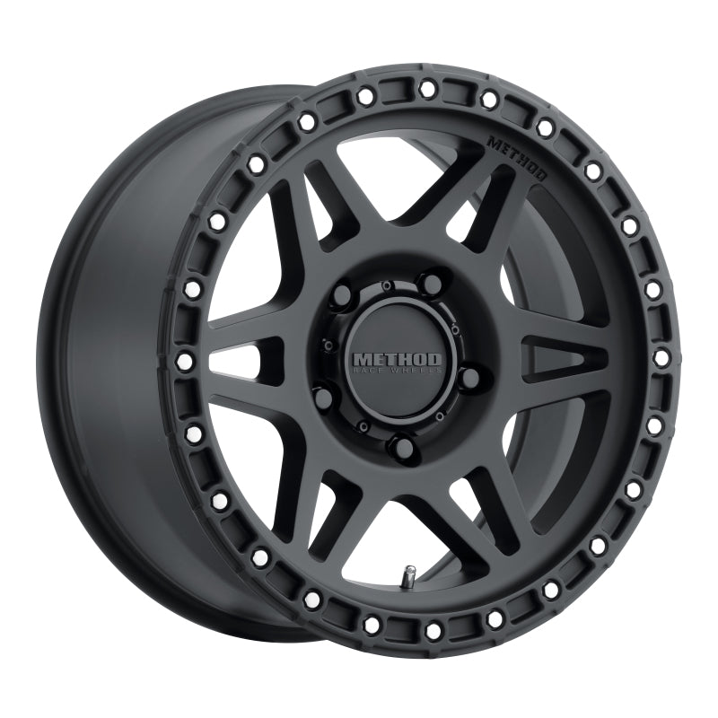 A black wheel with a center hole and rivets on the rim